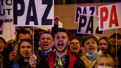 Un grupo de personas sostiene pancartas en una concentracin ante la embajada rusa en Madrid tras los primeros ataques rusos registrados en Ucrania.