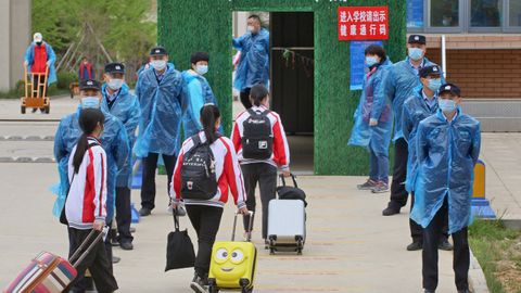 En la localidad china de Yantai los estudiantes han regresado a las aulas. Los policas supervisan su entrada con mascarillas y batas plsticas