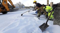 Los equipos de emergencias se afanan en limpiar la urea vertida en la rotonda de Bai�n.