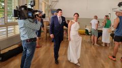 Pilar y Luis, reci�n casados, acuden a depositar su voto vestidos de novios y acompa�ados de amigos e invitados tras la celebraci�n del enlace.