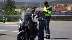 Un guardia civil examina la documentaci�n de un motorista.