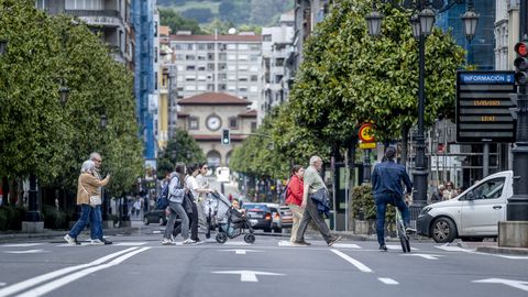 Varias personas cruzan por un paseo de peatones del centro de Oviedo