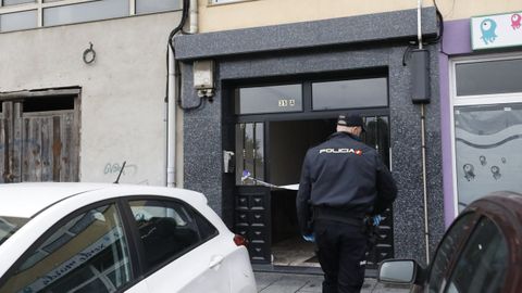 Un agente de polica ante el portal del edificio donde ocurri el crimen machista de Viveiro