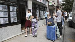 J�venes y estudiantes esperan frente a una inmobiliaria de Santiago.