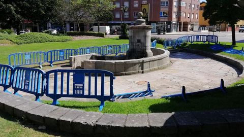 La fuente de Cuatro Caos, en La Corredoria, rodeada de vallas