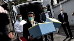 El Ministro de Trabajo y Asuntos Sociales de Alemania, Hubertus Heil, en el centro de la foto, con una m�scara protectora junto al alcalde de Potsdam, Mike Schubert (a la derecha) y un empleado de la Cruz Roja Alemana. Llevan cajas de comida para una cocina que se ocupa de personas desfavorecidas