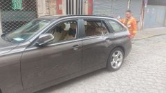 El propietario del veh�culo comprueba los da�os tras haberlo retirado de la acera donde lo ten�a aparcado junto al edificio en ruinas