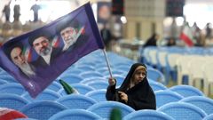 Una mujer iran� ondea una bandera con los rostros de Jomeini, Jamen�i y su hijo Mojtaba, en Teher�n