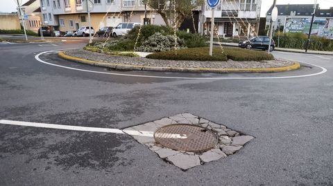Pavimento de hormig�n destrozado en el per�metro de una tapa de suministros, en la carretera de Catabois, que fue asfaltada este a�o.