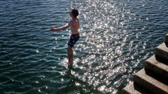 Un joven se lanza al mar desde el muelle del puerto de Vilanova de Arousa.