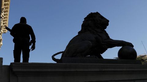 Un agente de la polic�a junto a la escultura del le�n del Congreso
