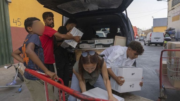 Diana Luaces cargando alimentos en una furgoneta con ayuda de j�venes migrantes
