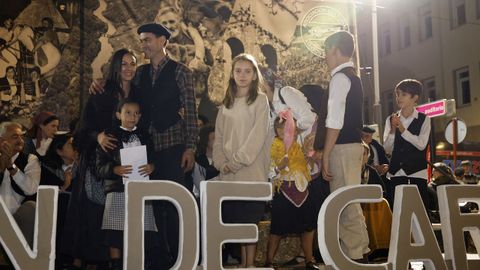 Miembros de los diferentes grupos participantes en el desfile de carros pasaron por el palco durante la entrega de los premios