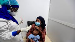 Una mujer y su hijo escuchan a una sanitaria que les realizar� la prueba para detectar el covid-19 en Dakar, Senegal