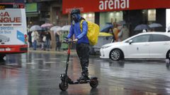 Un hombre circula con un patinete elctrico por las calles de A Corua.