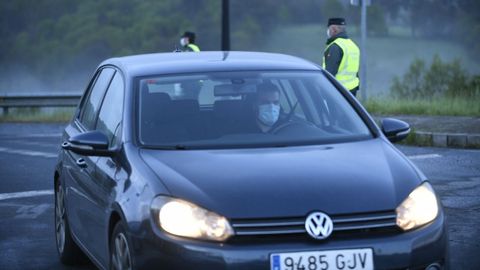 Reparto entrega de mascarillas por la guardia civil y policia local a trabajadores en la entrada del poligono industrial Lalin 2000