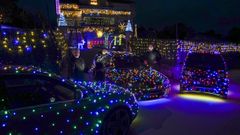 Coches y casas decoradas con luces de Navidad en A Mioteira.