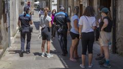 La plantilla de la Polic�a Local de Santiago, en la imagen dos agentes patrullan por la calle, se ve obligada a realizar horas extra para atender todos los servicios necesarios