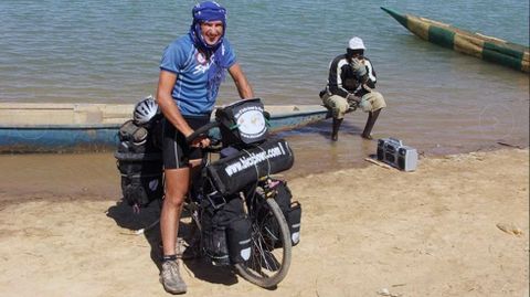 El biciclown posa junto a unas lanchas de pescadores en Senegal.El biciclown posa junto a unas lanchas de pescadores en Senegal 