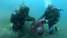 Submarinistas retirando desperdicios del fondo marino