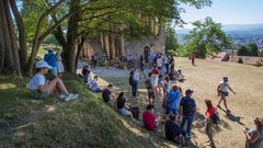 Grupos de turistas se protegen del calor en el exterior del monumento prerrom�nico de Santa Mar�a del Naranco