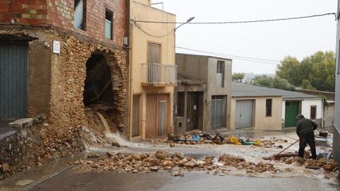 Un hombre recoge los escombros de una vivienda afectada por la dana