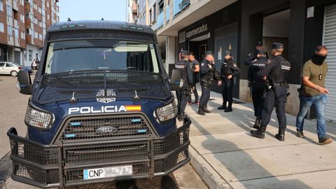 Agentes de la Policía Nacional custodiando uno de los edificios donde se registró el piso de un detenido este martes en Vilagarcía.