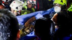 Varios efectivos de emergencia portan a una mujer de 32 a�os rescatada tras los terremotos de Colombia
