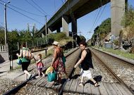 Una familia cruza el paso a nivel situado bajo el puente de Rande el pasado lunes.