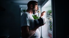 Un hombre comiendo a altas horas de la madrugada.