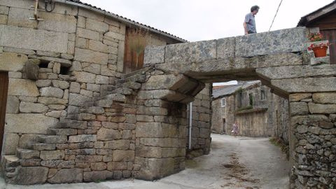 Un arco de bloques de pedra atravesa a vía principal de San Mamede