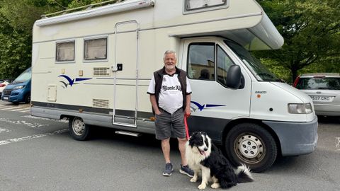 Juan Carlos junto a su caravana y Suso, su perro