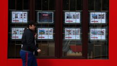 Un viandantes camina por delante de la vitrina de una agencia inmobiliaria en Barbanza.