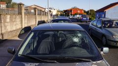 Foto del pasado viernes de un coche con la luna rota en Catabois, un suceso que se registra casi a diario en esta zona cercana al campamento de Los Chaquetas