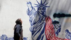 Una mujer pasa ante un mural cr�tico con Estados Unidos creado en la zona donde estaba la embajada norteamericana