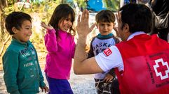 Un voluntario de Cruz Roja jugando con ni�os en el campamento de Ritsona (Grecia)