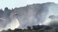 Un helic�ptero arroja agua sobre el incendio este domingo por la ma�ana en Ribas de Sil