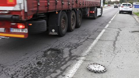 Peligrosa rotura del asfalto en la carretera de Catabois, frente a la gasolinera, con un tapacubos en el arc�n.