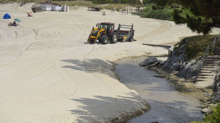 Trabajos de redistribuci�n de la arena en la playa de Areas, en Sanxenxo