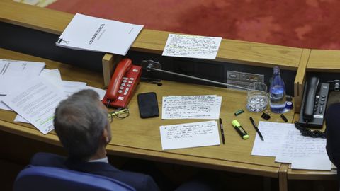 Alfonso Rueda, desde su escao en el Parlamento, escuchando la rplica de la oposicin, con sus notas sobre la mesa.