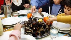 Ni�os comiendo mejillones frescos en un colegio gallego (foto de archivo)