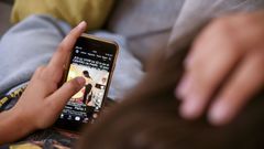 Una adolescente consulta una red social en su m�vil.