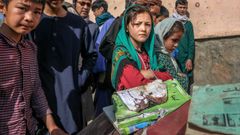 Un grupo de escolares vigilan los libros y cuadernos  manchados de sangre de sus compa�eros muertos en el atentado en la escuela de Kabul