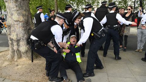 La polic�a londinense bloquea el paso a un grupo de manifestantes que protestaron hoy contra el confinamiento, ante la sede de Scotland Yard