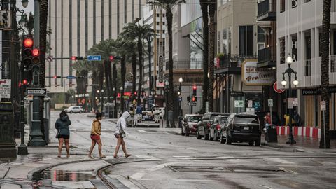 Un grupo de mujeres cruzando Canal Street entre la lluvia y viento ocasionado por el hurac�n