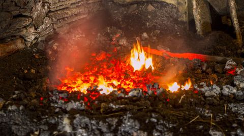 Una barra de hierro calentndose al rojo vivo en el fuego de la fragua