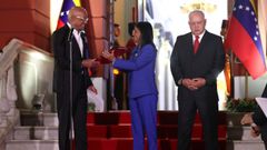 Delcy Rodr�guez, con el documento de la ley en las manos, sonr�e al presidente de la Asamblea, su hermano Jorge Rodr�guez, en presencia del ministro del Interior, Diosdado Cabello