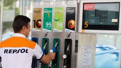 Un empleado de una gasolinera con un surtidor de gasolina 98. ARCHIVO