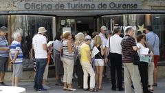 Un grupo de visitantes hace cola a las puertas de una oficina de informaci�n tur�stica en la ciudad de Ourense