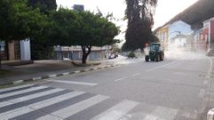 Un tractor provisto de un pulverizador industrial desinfecta las calles de Quiroga